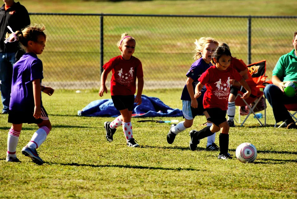 Des enfants jouent au football sur un terrain (image d'illustration)