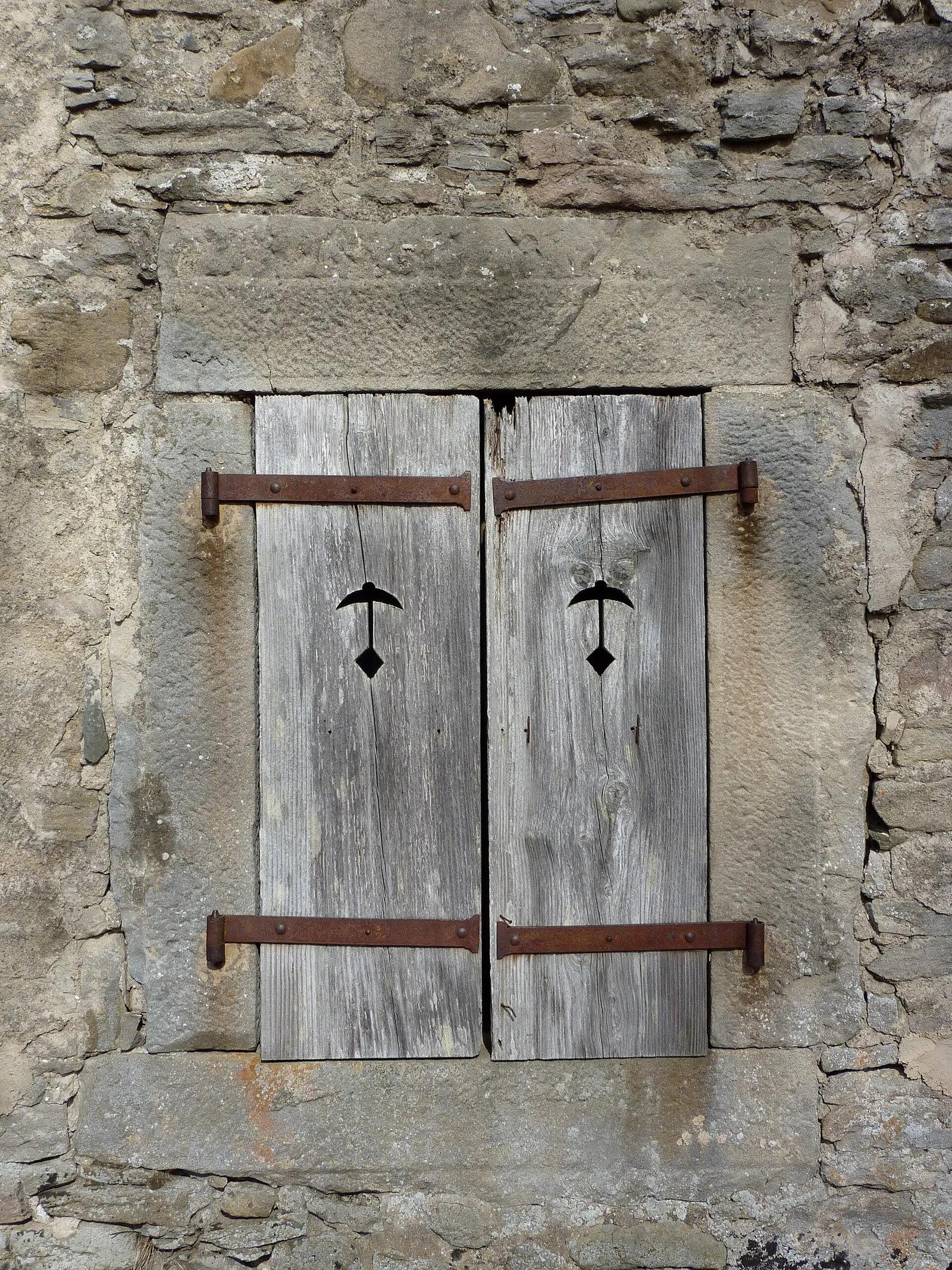 Un volet de fenêtre fermé sur une façade, en France